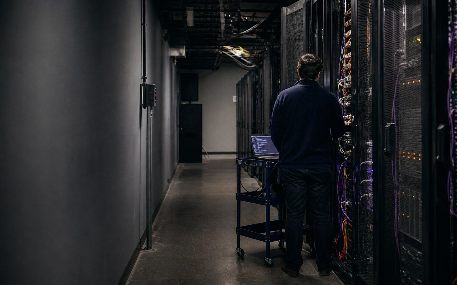 Editorial illustration of an infrastructure engineer working locally beside enterprise CPU server racks.